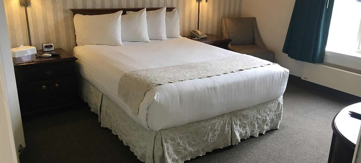 Cozy Accessible Room photo of our accessible room with queen size bed, night stands, lamps, sitting chair, alarm clock and direct dial phone. Large window for viewin