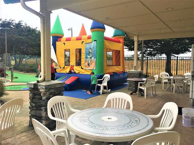 Emerald dolphin's bounce house photo of 2 children playing in the bounce house at Emerald Dolphins / Ed's Mini golf and arcade.