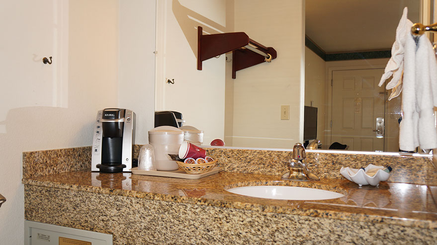 The Cozy Queen Guest Room Photo showing large sink area with coffee maker and coffee, cups, bath essentials.