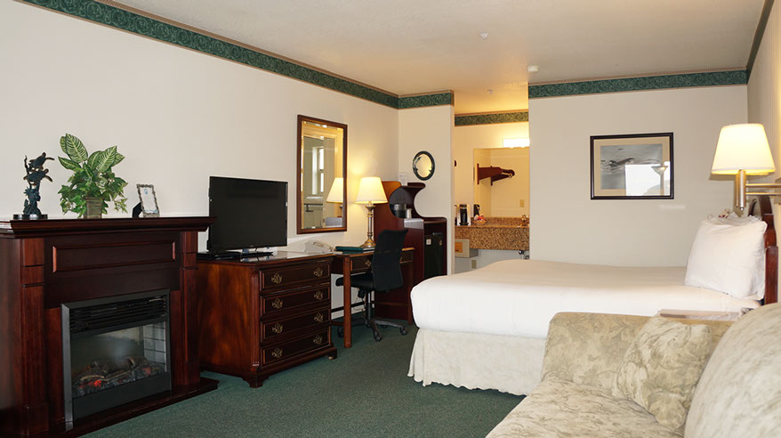 European King Size Bed This spacious room is showing a European King Bed, Electric Fireplace, Chest of Drawers, Flat Screen TV, Writing Desk, Microwave and Mini Fridg.