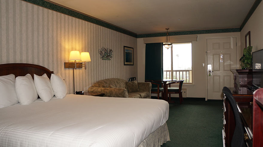 European King Bed Guest Room Photo showing European King Bed, sofa, table and chairs, large window, and fine furnishings.