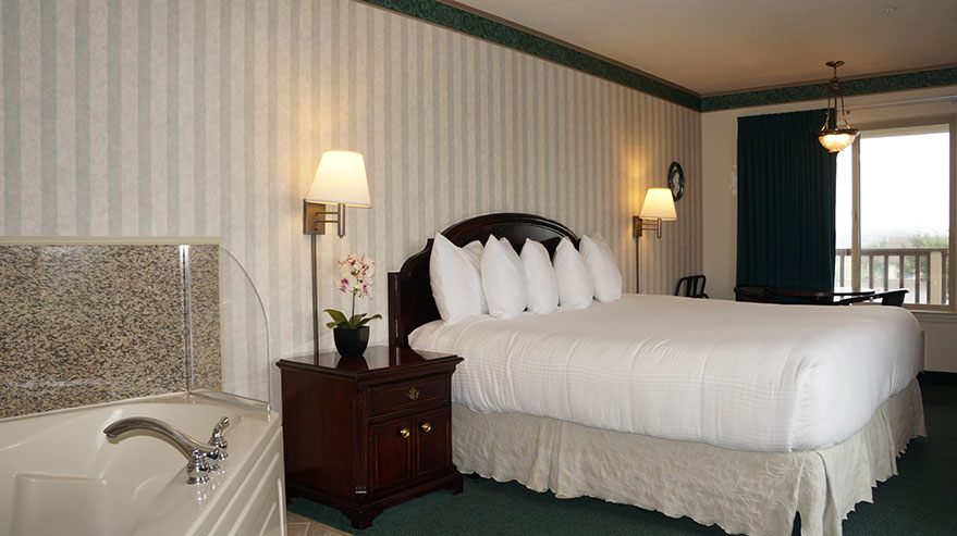 European King Size Bed European King Size Bed guest room photo showing King bed, jacuzzi tub, night stand, lamps and large window.