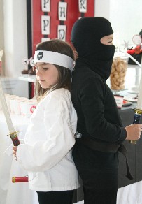photo showing 2 young children dressed in karate and ninja outfits for a party.