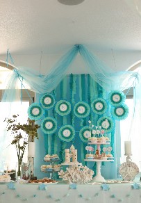 photo of a beautiful display of soft blue pastels, cupcakes and decorations.
