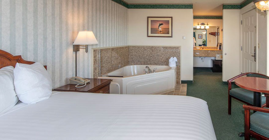 Queen Size Guest Room This pho shows our Queen size bed, Jacuzzi tub seats two. A Chest of drawers, night stand, lamp, alarm clock, direct dial phone and decorations