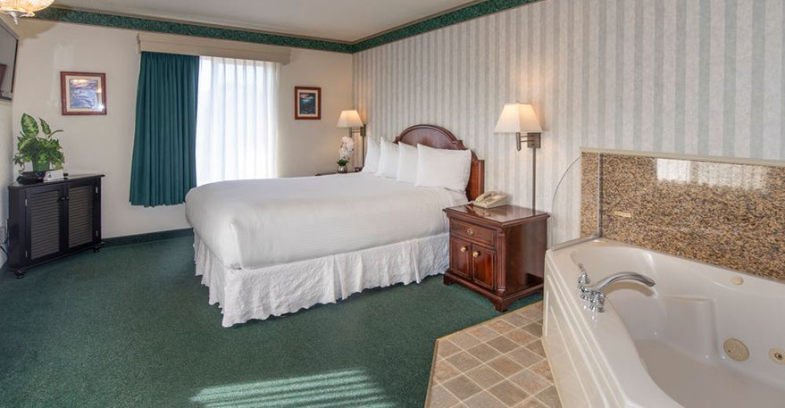 Queen Size Guest Room This pho shows our Queen size bed, Jacuzzi tub seats two. A Chest of drawers, night stand, lamp, alarm clock, direct dial phone and decorations