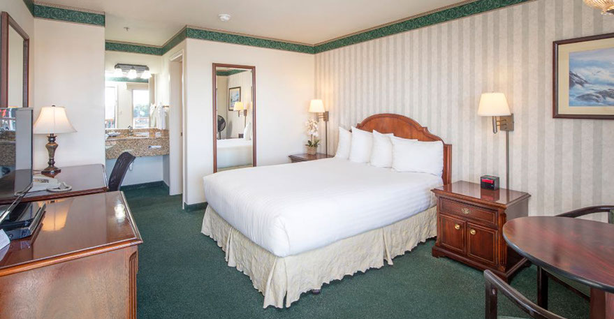 The Cozy Queen Guest Room This photo shows our cozy guest room with a queen bed, 2 night stands, lamps, alarm clock and full length mirror.