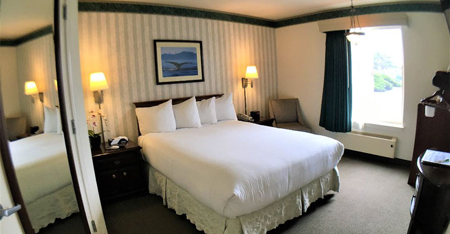 Cozy Queen Accessible Room Photo showing our accessible queen room with a queen size bed with 2 night stands, lamps, alarm clock and direct dial phone.