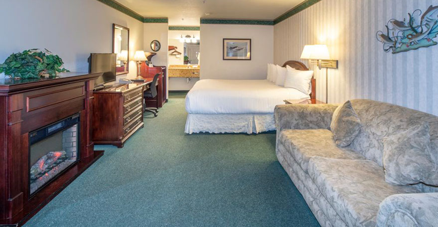 European King Size Bed This spacious room is showing a European King Bed, Electric Fireplace, Chest of Drawers, Flat Screen TV, Writing Desk, Microwave and Mini Fridg.